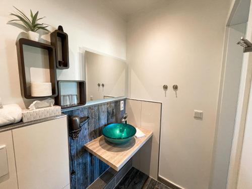 a bathroom with a green sink and a mirror at RiBecca in Weyhe