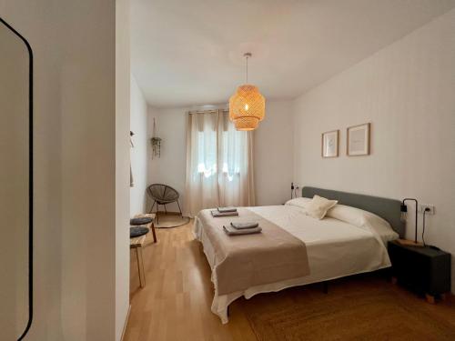 a bedroom with a bed and a chandelier at Cozy apartment well-located in Terrassa, Barcelona in Terrassa