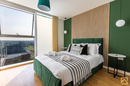 a green bedroom with a large bed and a large window at Stunning 1-bed, Central MK, Free Parking, Smart TV By Valore Property Services in Milton Keynes