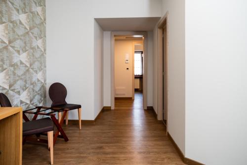 a corridor of a room with a chair and a table at Le Torri - Castiglione Falletto in Castiglione Falletto