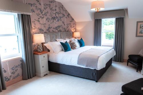 Un dormitorio con una cama grande con almohadas azules. en The Ruddings, en Keswick