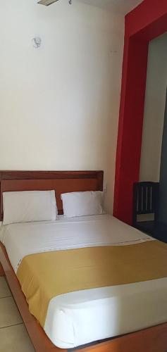 a bed in a room with a red and white at Hotel Pacific in Tecomán