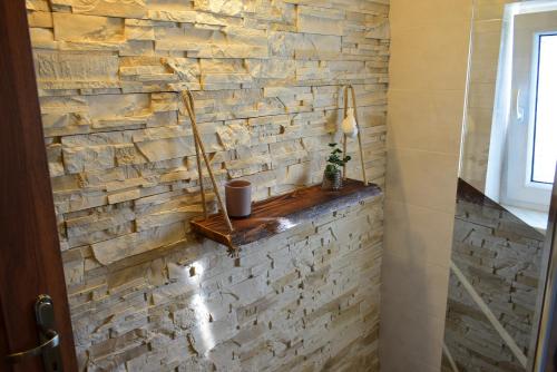 a stone wall in a bathroom with a shelf at Ubytovanie u Adama in Oščadnica