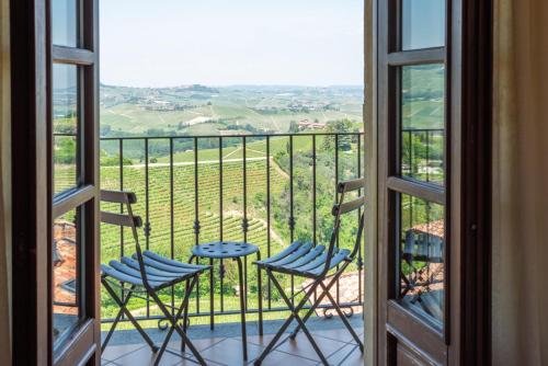 a balcony with two chairs and a view of the countryside at Le Torri - Castiglione Falletto in Castiglione Falletto