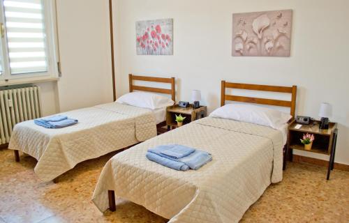 een kamer met 2 bedden en handdoeken erop bij Casa Fiume in Mantova