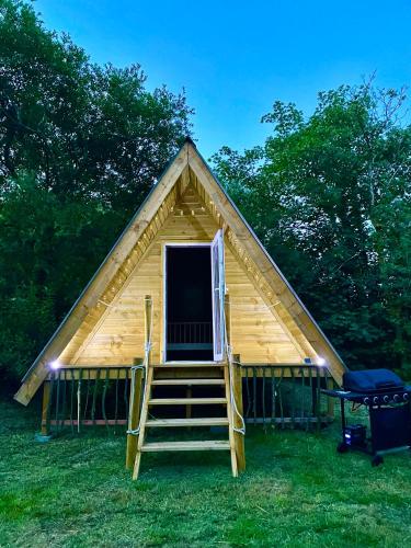 a cabin with a staircase leading to a thatched roof at Robin Goch Retreat in Carmarthen