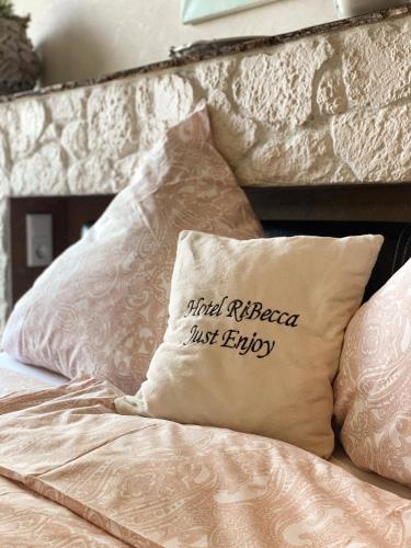 a bed with a pillow that reads killed rational just enjoy at RiBecca in Weyhe