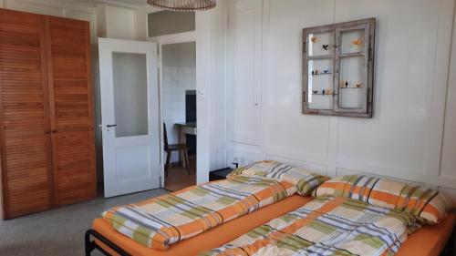 Schlafzimmer mit einem Bett und einem Wandspiegel in der Unterkunft Tor zum Toggenburg in Bazenheid