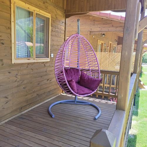 a purple swinging chair on a porch of a cabin at Fidelya Bungalow Evleri in Adrasan