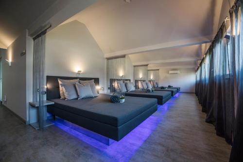 eine Reihe von Betten in einem Zimmer mit lila Lichtern in der Unterkunft Hotel Hoeri am Bodensee in Gaienhofen