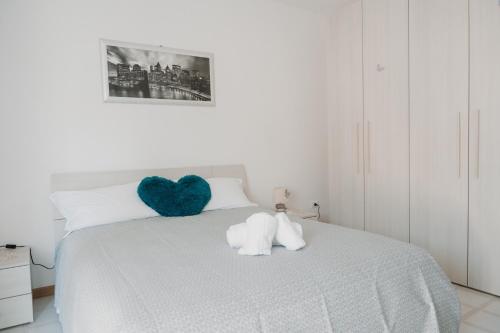 a bedroom with a white bed with a heart pillow at Casa vacanze La Farfalla in San Vito Chietino