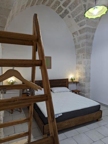 a bedroom with a bunk bed and a ladder at Masseria Petrore Grande di Polimeno Alessandra in Cutrofiano