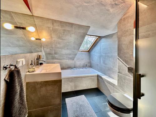 uma casa de banho com uma banheira, um WC e um lavatório. em Atelierhaus Meißen em Meissen