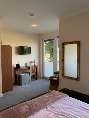 a bedroom with a bed and a mirror and a desk at RiBecca in Weyhe