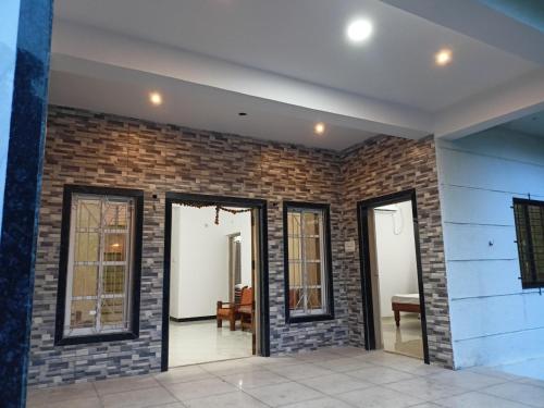 Cette chambre est dotée d'un mur en briques et de fenêtres. dans l'établissement Green Valley Resort, à Thāl