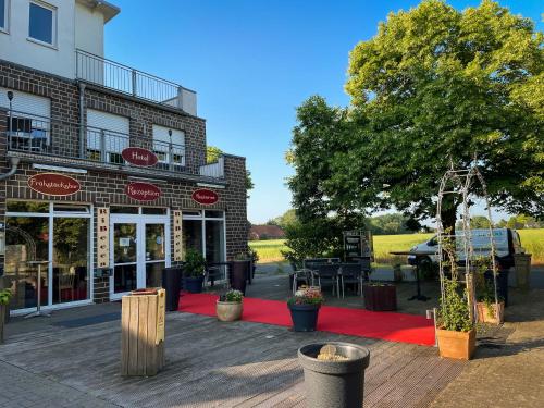 a restaurant with a red rug in front of a building at RiBecca in Weyhe