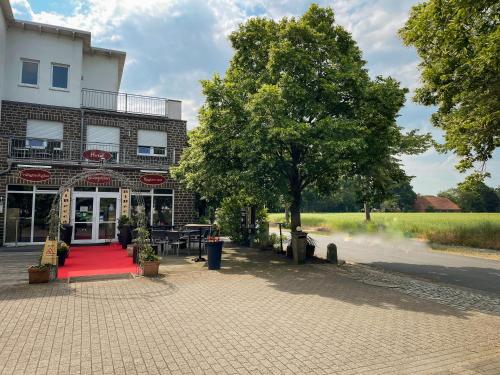 a red carpet in front of a building with a tree at RiBecca in Weyhe