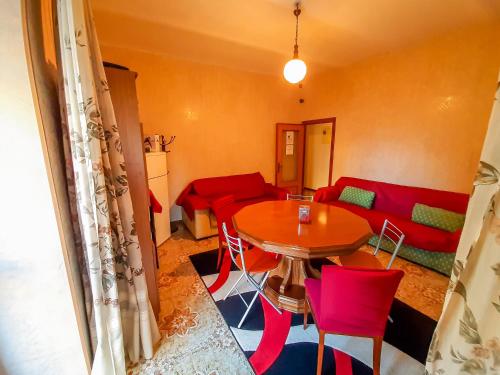 sala de estar con mesa y sofá rojo en Bed & Breakfast "Il Ghiro" en San Martino sulla Marruccina