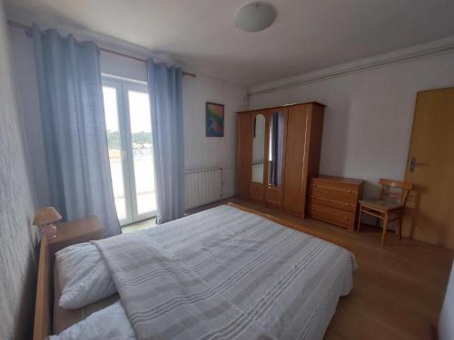 a bedroom with a large bed and a window at Piadora in Banjol