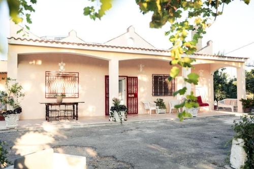 une maison blanche avec une table devant elle dans l'établissement Casa in campagna ⋅ ForiMìa, à San Vito dei Normanni