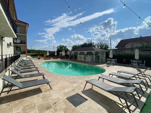 una piscina con tumbonas en un patio en Vila Dedy, en Costinesti