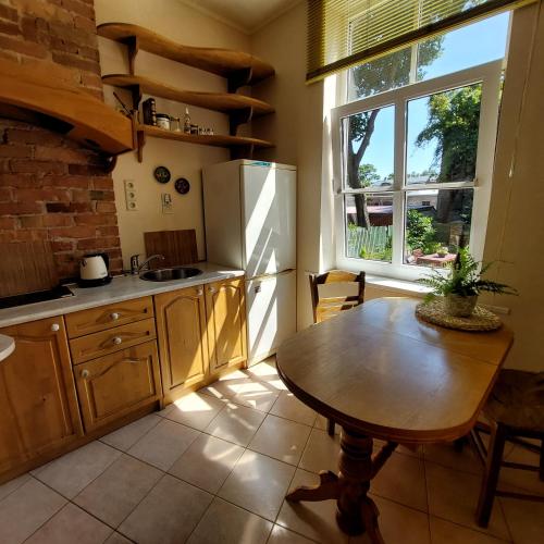 una cucina con un tavolo, un frigorifero e una finestra di Stendera 5 a Liepāja