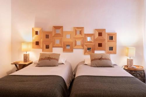 two beds in a room with wooden frames on the wall at Casas de Campo do Castro da Cola in Marchicão