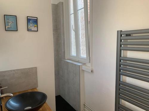 un taburete negro en una habitación con ventana en Chrysalide au cœur du Touquet., en Le Touquet-Paris-Plage