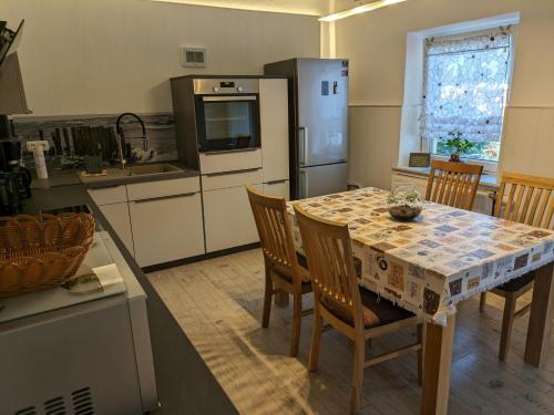 eine Küche mit einem Tisch mit Stühlen und einem Kühlschrank in der Unterkunft Idyll im Land der 1000 Seen in Liessow