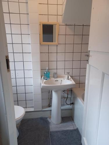 een badkamer met een wastafel, een toilet en een bad bij Newcastle Home in Saint Peters