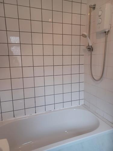 een badkamer met een bad en een douche bij Newcastle Home in Saint Peters