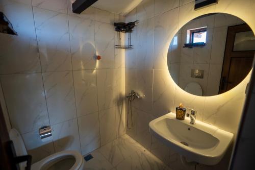 een witte badkamer met een wastafel en een spiegel bij Villa Asmaaltı in Demre