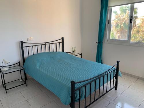 ein Schlafzimmer mit einem Bett mit blauer Decke und einem Fenster in der Unterkunft Holiday Home Emba in Emba