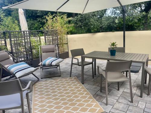 卡斯蒂利翁切洛的住宿－Via Zug，庭院配有桌椅和遮阳伞。