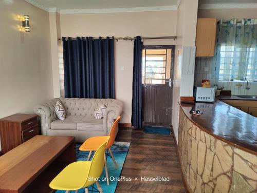 a living room with a couch and a table at Fadhili House in Naivasha