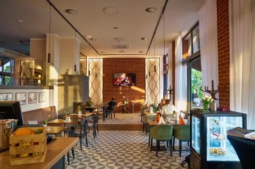 a restaurant with tables and chairs and a brick wall at Wellness Hotel Queens in Mariánské Lázně