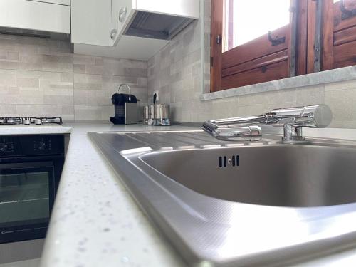 uma cozinha com um lavatório de aço inoxidável numa cozinha em Villa Berenice em Pachino