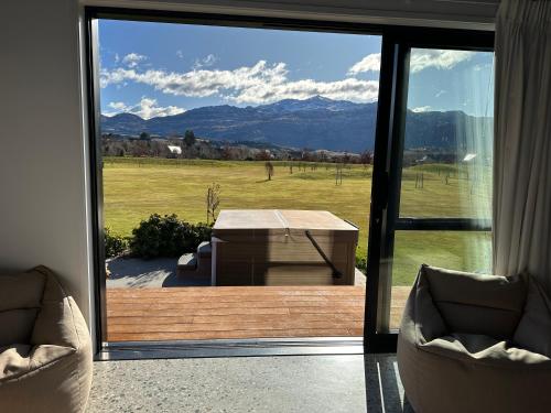 um quarto com uma porta de vidro deslizante com uma mesa e uma vista em Guest House with a Stunning View em Frankton