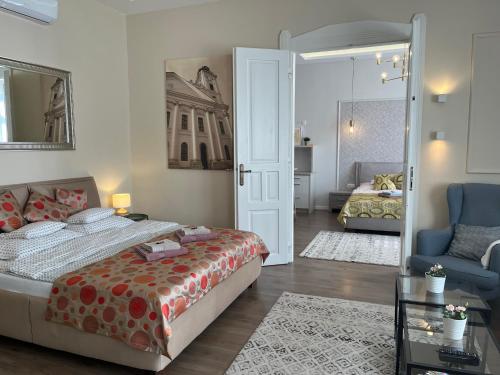 a bedroom with a bed and a couch and a chair at Visit Debrecen Apartman in Debrecen