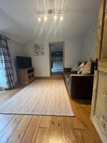 sala de estar con sofá y alfombra en The Annexe, en Winterbourne