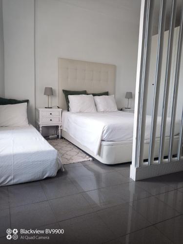two beds in a bedroom with white walls at Oporto apartment Batalha in Porto