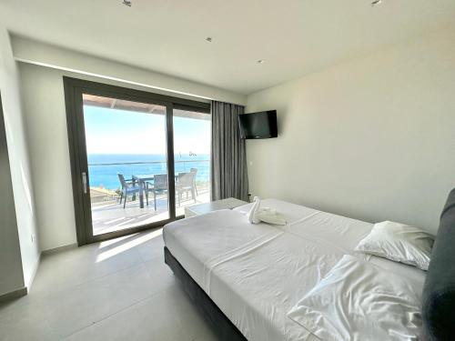 a bedroom with a bed and a view of the ocean at Aristomenis Studios in Vlachata