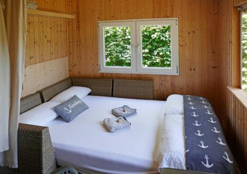 Cama en habitación con 2 ventanas en Refugio del Lago, en Seekirchen am Wallersee