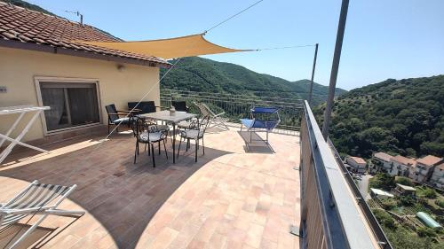 een patio met een tafel en stoelen op een balkon bij Cerasa in Rodio
