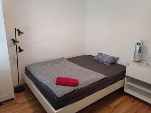 sypialnia z łóżkiem z czerwoną poduszką w obiekcie City Home Zurich w Zurychu