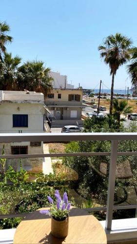 a balcony with a flower pot on a table at Sea Through Apartment Anavissos in Anavissos
