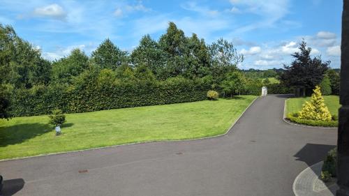 a walkway through a park with trees and grass at Brodleys' Hill Studio 286d in Ballymena