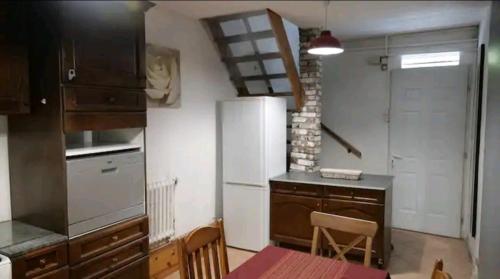 a kitchen with a refrigerator and a table in it at Comme une petite maison en ville in Montrouge