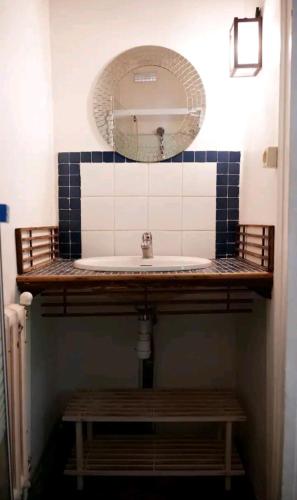 une salle de bain avec un lavabo et un miroir dans l'établissement Une petite maison en ville, à Montrouge
