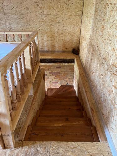 a wooden staircase in a building with a brick wall at Forest INN in Antaramej